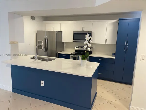a kitchen with kitchen island sink refrigerator and stove