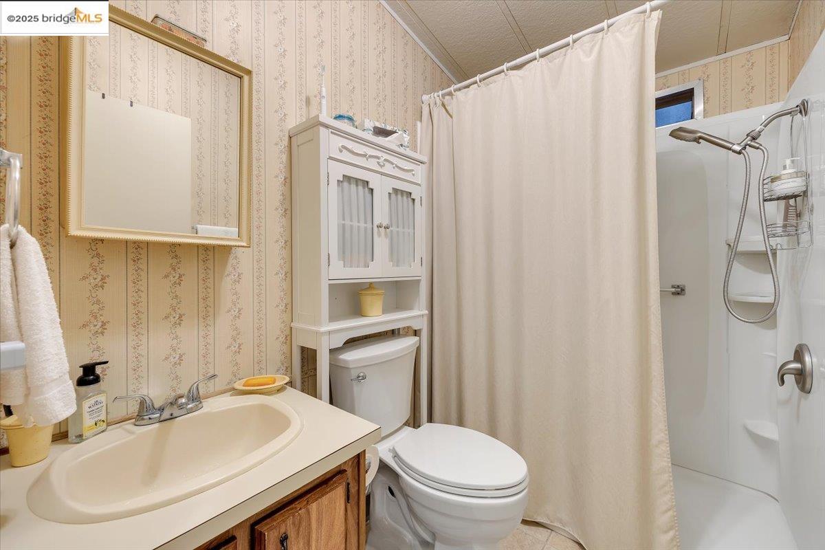 14192 Tuolumne Road, Unit 67 Sonora, CA 95370 - Photo 11 of 26 a bathroom with a sink a toilet and shower curtain