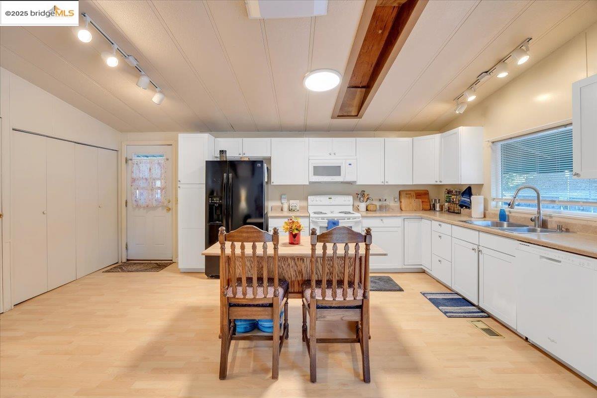 14192 Tuolumne Road, Unit 67 Sonora, CA 95370 - Photo 19 of 26 a kitchen with stainless steel appliances a dining table chairs refrigerator and microwave