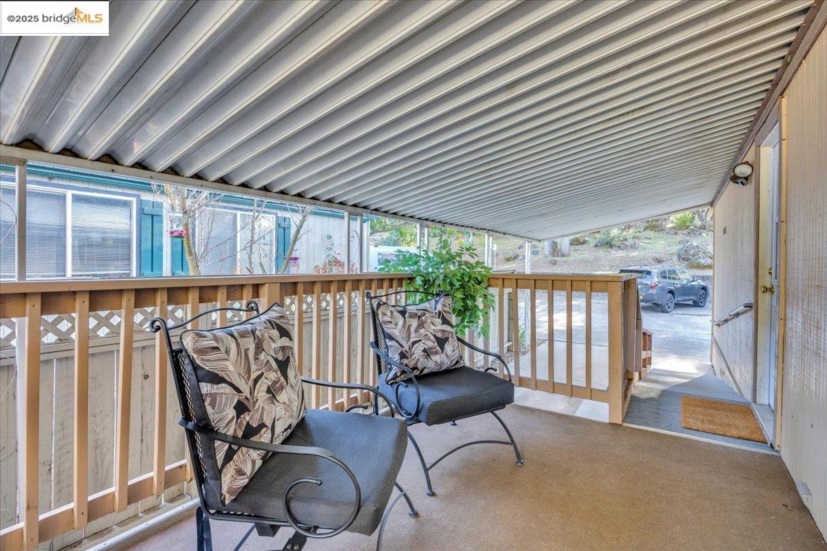 14192 Tuolumne Road, Unit 67 Sonora, CA 95370 - Photo 6 of 26 a view of a patio with table and chairs with wooden floor and fence and floor to ceiling window