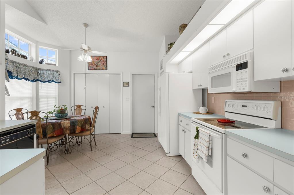 9426 Mississippi Run Weeki Wachee, FL 34613 - Photo 8 of 31 a kitchen with cabinets table and chairs