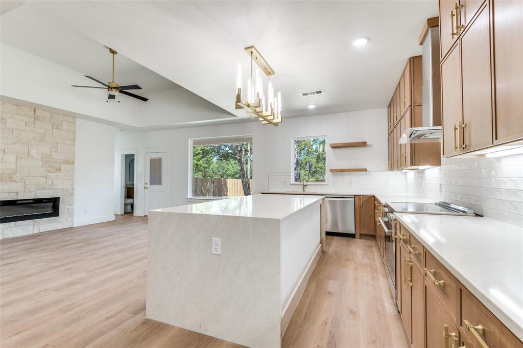 3913 Blue Ridge Boulevard Dallas, TX 75233 - Photo 11 of 25 Spacious kitchen with a large central island, stainless steel appliances, and wood-finish flooring