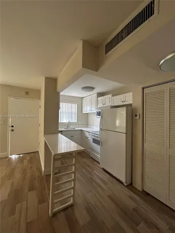 a view of a kitchen with furniture and an empty room