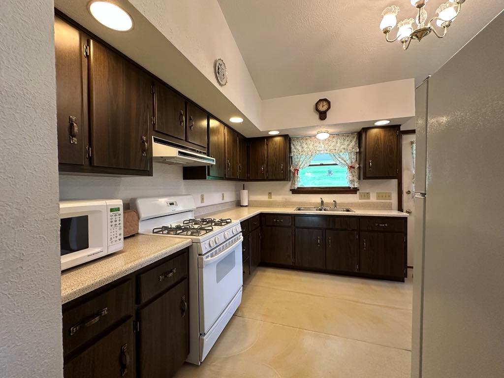 861 Chicora Road Chicora, PA 16025 - Photo 6 of 30 a kitchen with stainless steel appliances granite countertop a stove a sink dishwasher and a microwave oven with large cabinets