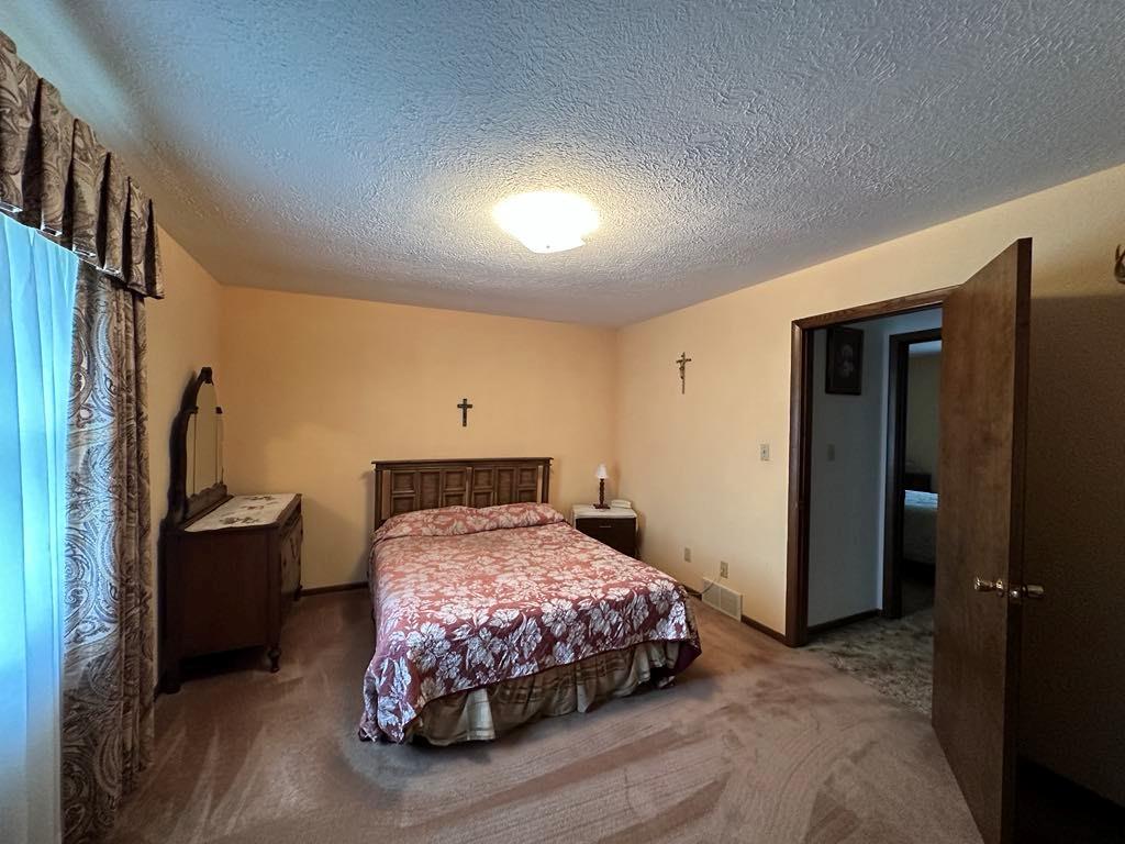861 Chicora Road Chicora, PA 16025 - Photo 10 of 30 a bedroom with a bed and a refrigerator