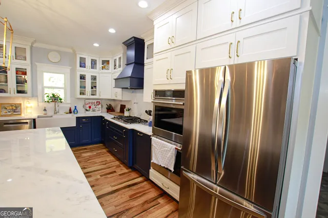 a large kitchen with stainless steel appliances and a refrigerator