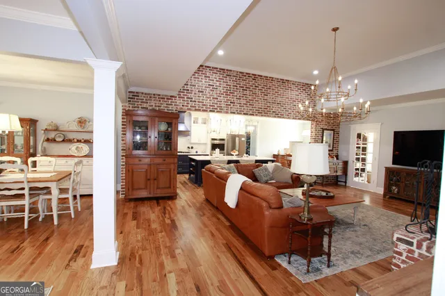 a living room with furniture a fireplace and a chandelier