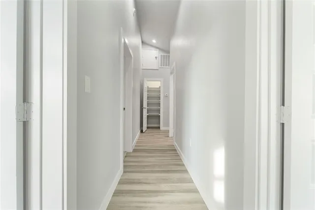 a view of a hallway with wooden floor