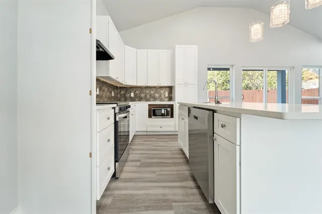 a kitchen with stainless steel appliances granite countertop a stove and a refrigerator