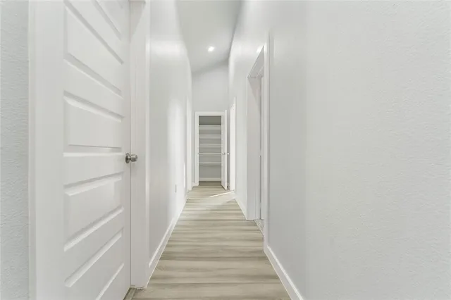 a view of a hallway with wooden floor and entryway