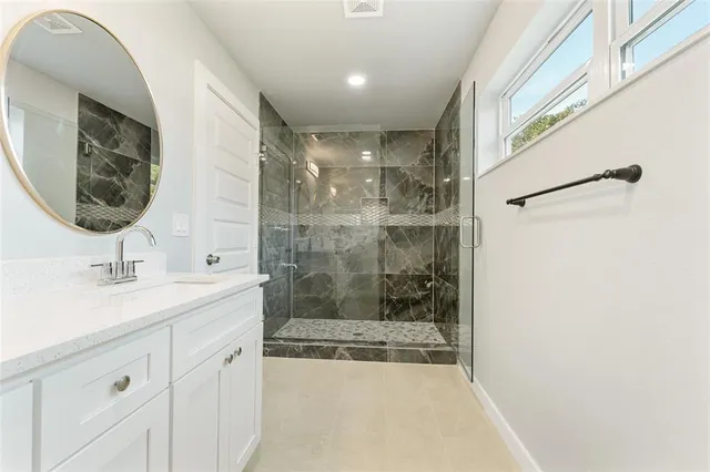 a bathroom with a sink a mirror and a shower