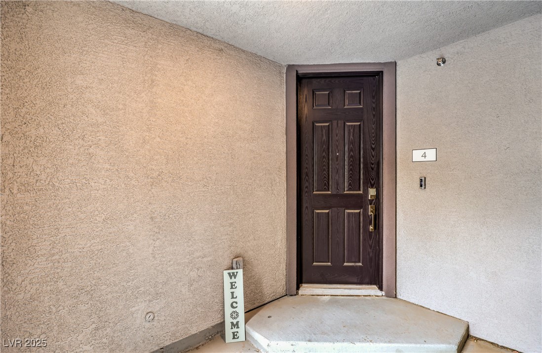 7232 North Decatur Boulevard, Unit 4 North Las Vegas, NV 89084 - Photo 3 of 36 Doorway to property with stucco siding