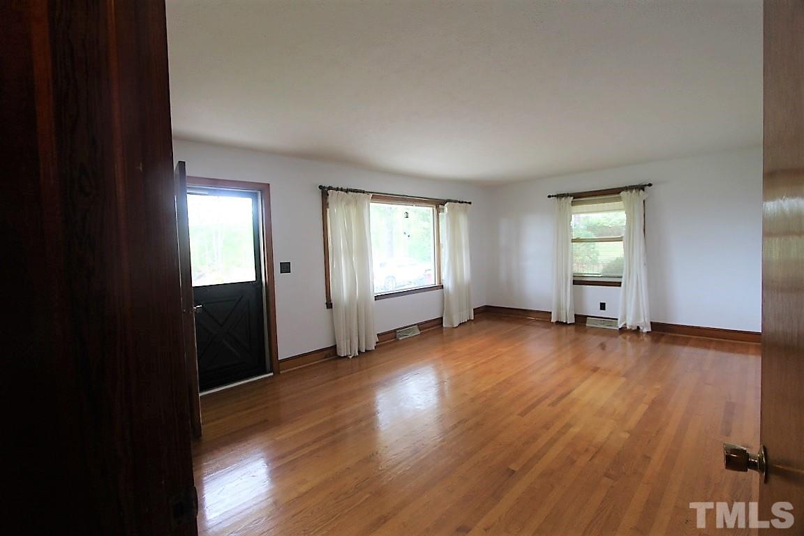 199 Carver Holt Road Roxboro, NC 27574 - Photo 5 of 23 an empty room with wooden floor and windows