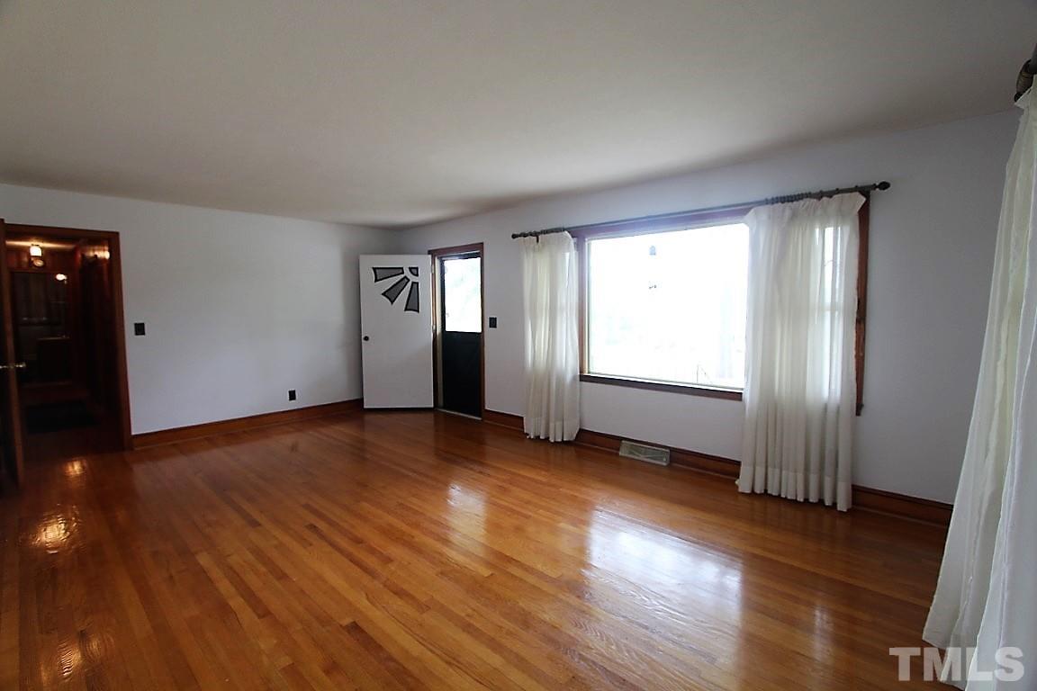 199 Carver Holt Road Roxboro, NC 27574 - Photo 6 of 23 an empty room with wooden floor and windows