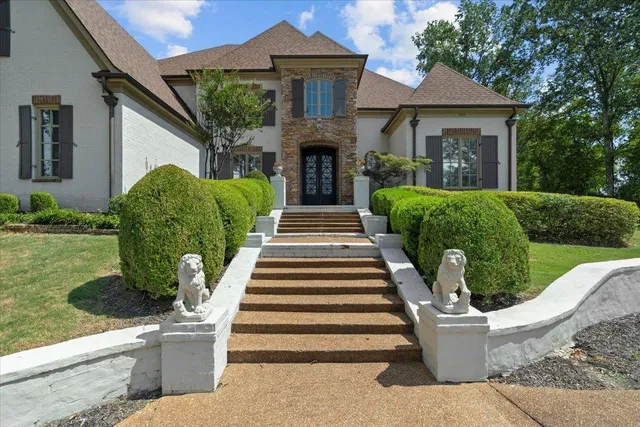 a front view of a house with a garden and plants