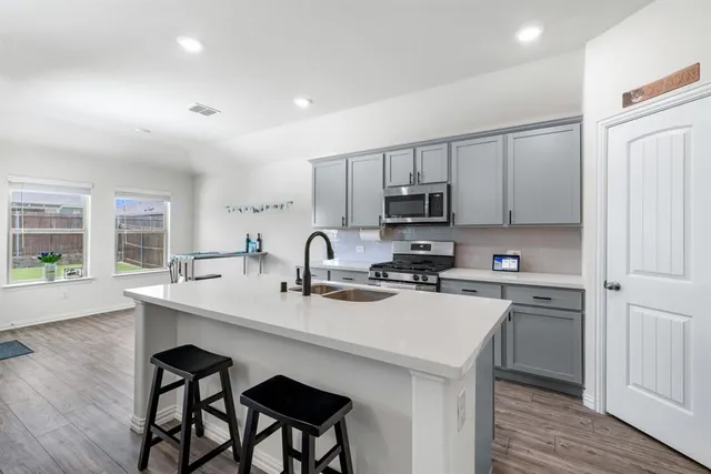 a kitchen with appliances a sink and cabinets