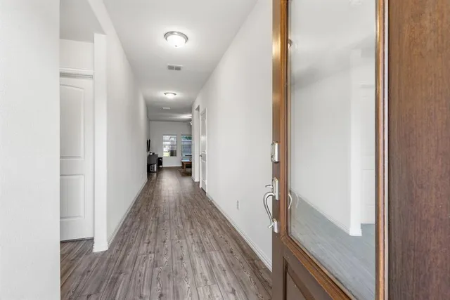 a view of a hallway with wooden floor and staircase