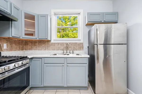 a kitchen with appliances a sink and a window