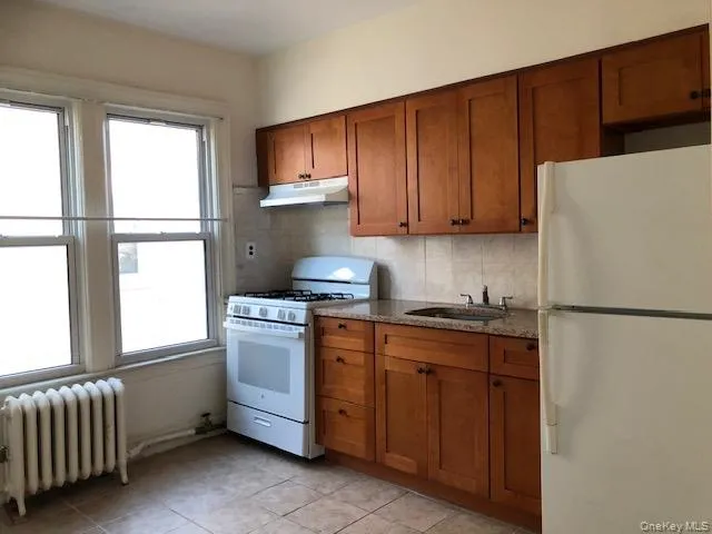 a kitchen with a refrigerator sink and cabinets