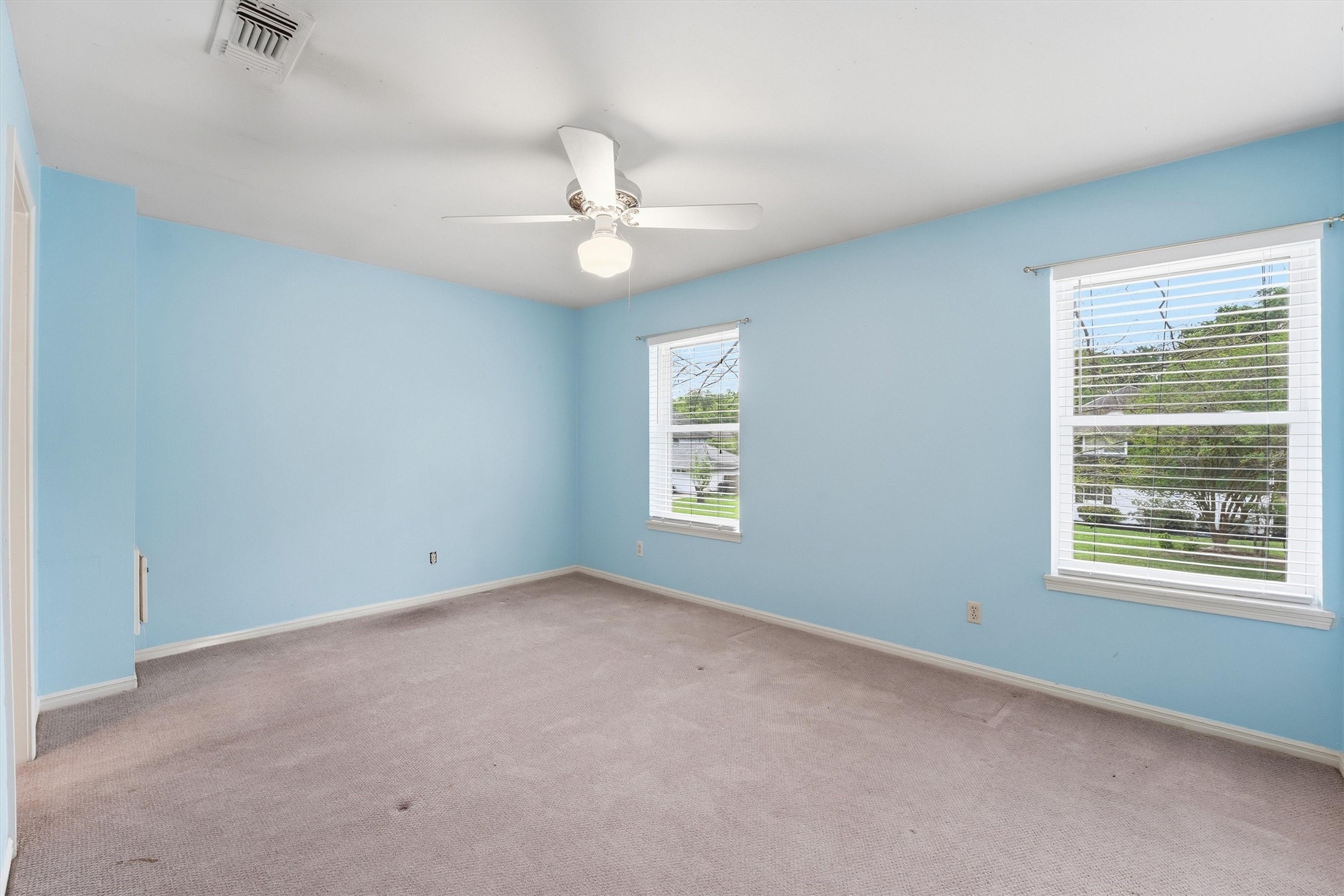 8115 Theisswood Road Spring, TX 77379 - Photo 27 of 36 an empty room with a window and ceiling fan