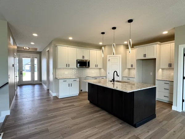 a kitchen with stainless steel appliances granite countertop a sink refrigerator and cabinets