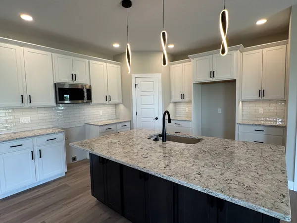 a kitchen with kitchen island granite countertop a counter space cabinets and appliances