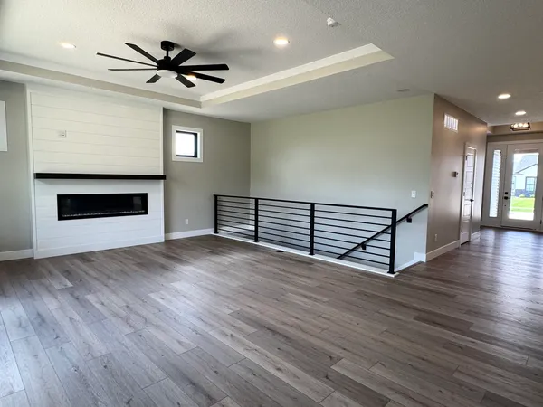 a view of a livingroom with wooden floor and a ceiling fan
