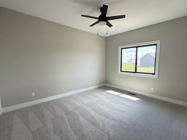 an empty room with a window and a fan