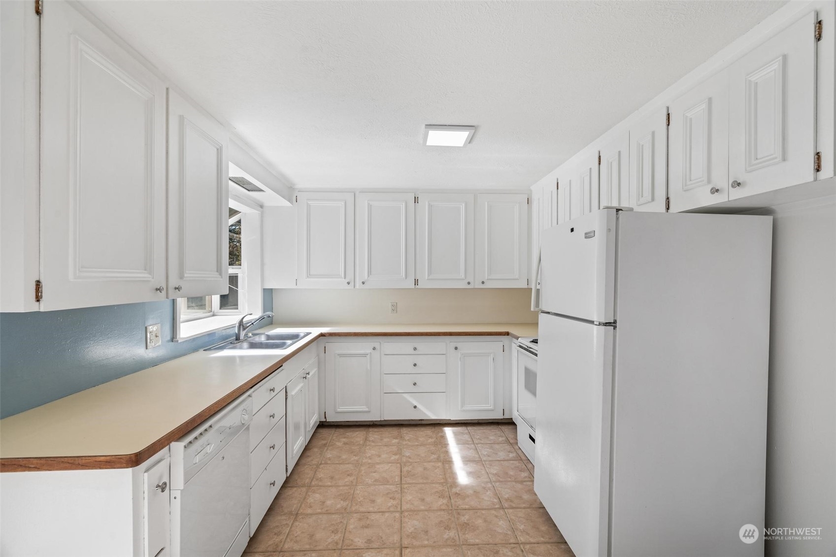229 V Street Southwest Tumwater, WA 98501 - Photo 6 of 38 a kitchen with sink a refrigerator and white cabinets