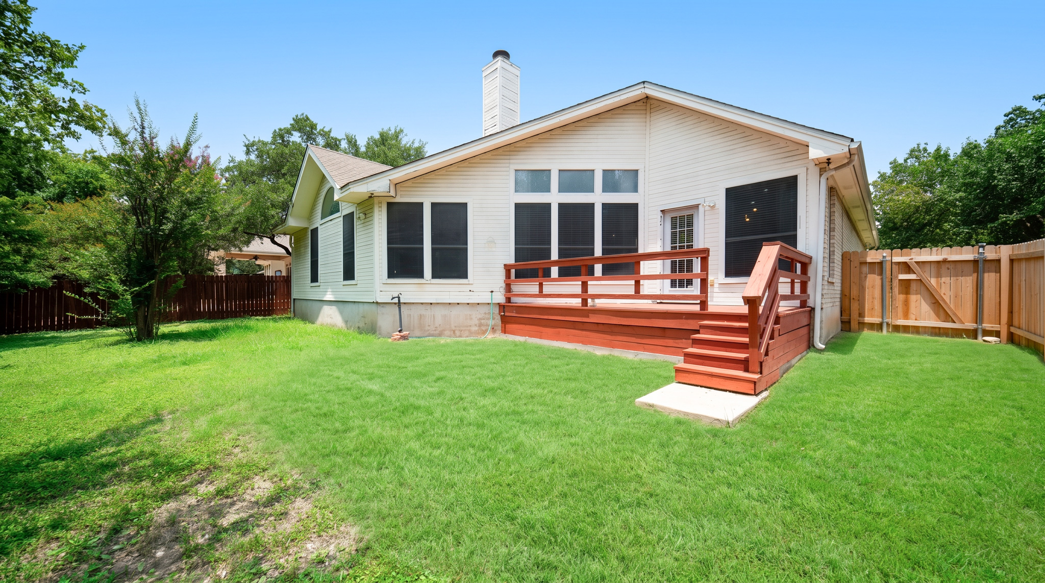 1108 Antelope Ridge Cedar Park, TX 78613 - Photo 23 of 27 A vibrant green lawn extends to a charming wooden deck, perfect for outdoor enjoyment.