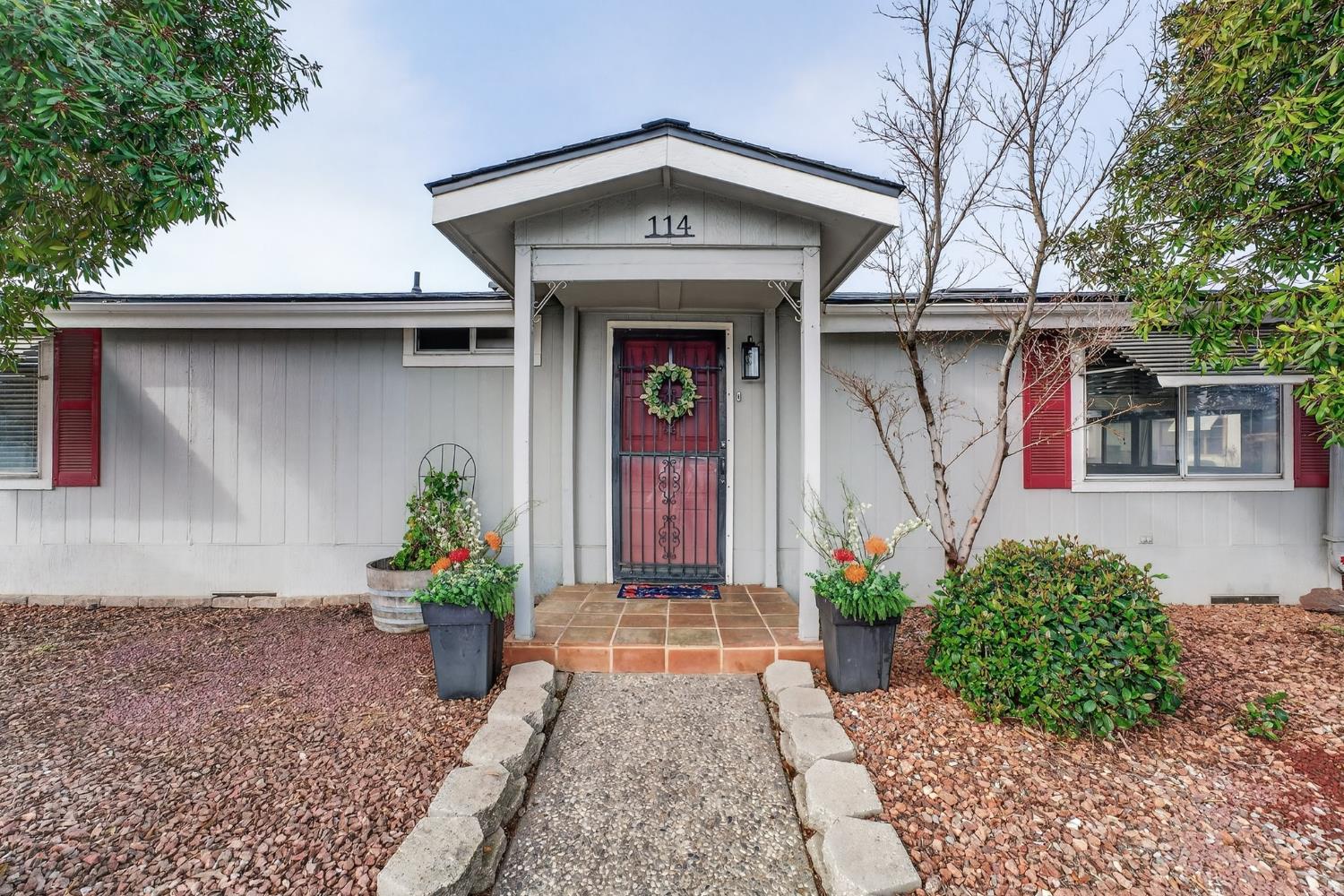 2755 North Walnut Road, Unit 114 Turlock, CA 95382 - Photo 2 of 28 a front view of a house with potted plants