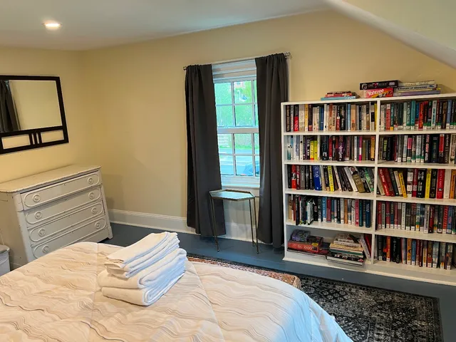 a bedroom with a bed and a book shelf
