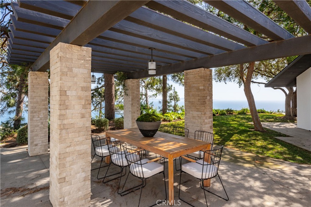 71 Crest Road East Rolling Hills, CA 90274 - Photo 16 of 23 a view of an outdoor dining space with a table and chairs under an umbrella