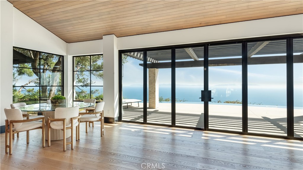 71 Crest Road East Rolling Hills, CA 90274 - Photo 8 of 23 a dining room with wooden floor glass walls and windows