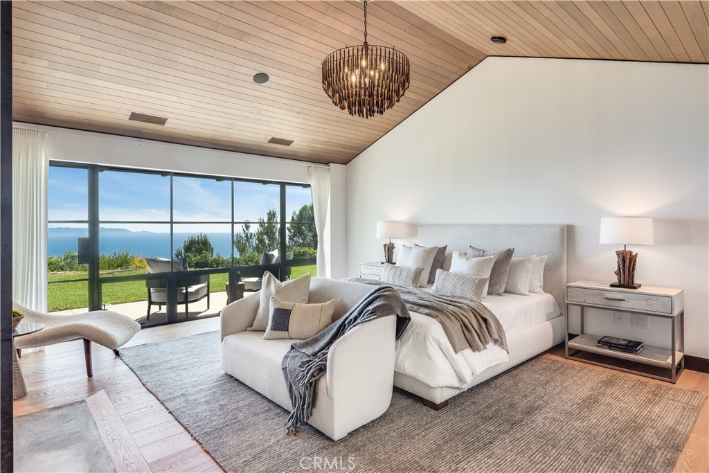 71 Crest Road East Rolling Hills, CA 90274 - Photo 10 of 23 a spacious bedroom with a bed a couch and large window with balcony view