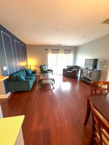 a living room with furniture and a wooden floor