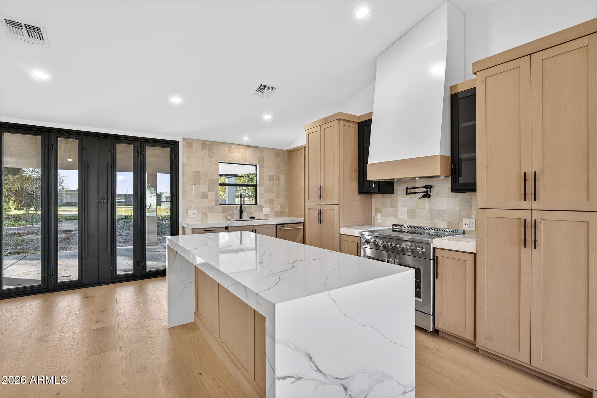 2223 East Claxton Avenue Gilbert, AZ 85297 - Photo 10 of 56 a kitchen with stainless steel appliances granite countertop a refrigerator a stove and a sink with wooden floor