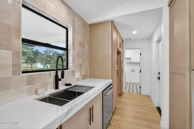 a kitchen with stainless steel appliances granite countertop a refrigerator a stove and a sink with wooden floor