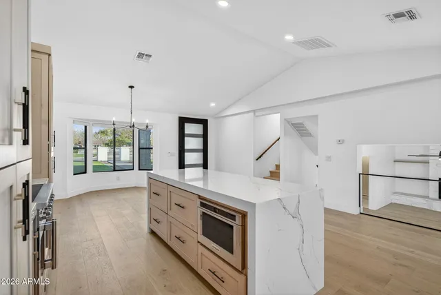 a large white kitchen with a large window
