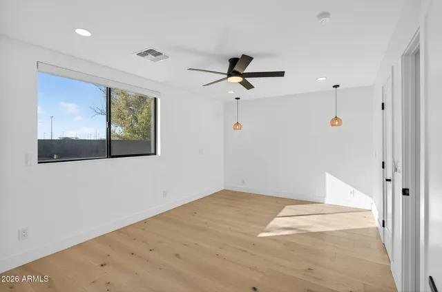 an empty room with a window and a ceiling fan