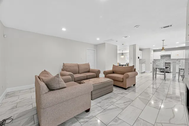 a living room with furniture and a dining table with kitchen view