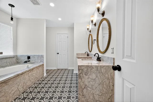 a bathroom with a bathtub sink and mirror
