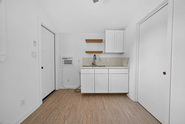 a room with a sink cabinets and wooden floor