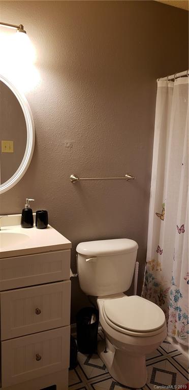4489 Norfleet Street Concord, NC 28025 - Photo 15 of 23 a white toilet sitting next to a bathroom sink and a mirror