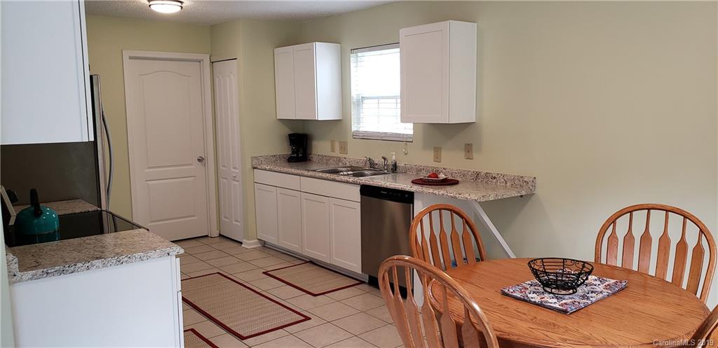 4489 Norfleet Street Concord, NC 28025 - Photo 9 of 23 a kitchen with stainless steel appliances granite countertop a stove top oven a sink a refrigerator and white cabinets