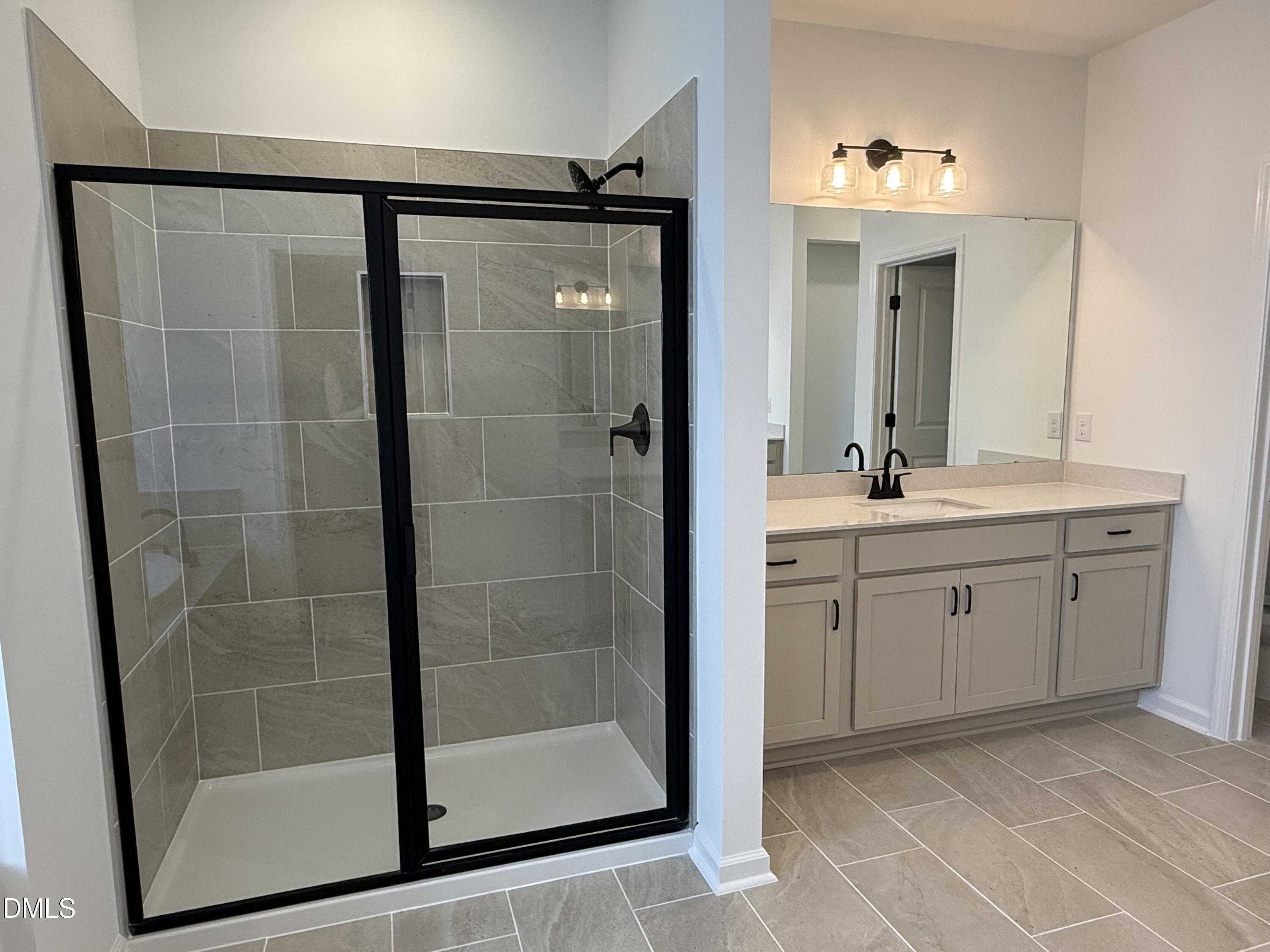 433 Contempo Court, Unit 3 Rolesville, NC 27571 - Photo 19 of 40 a spacious bathroom with a shower sink and mirror