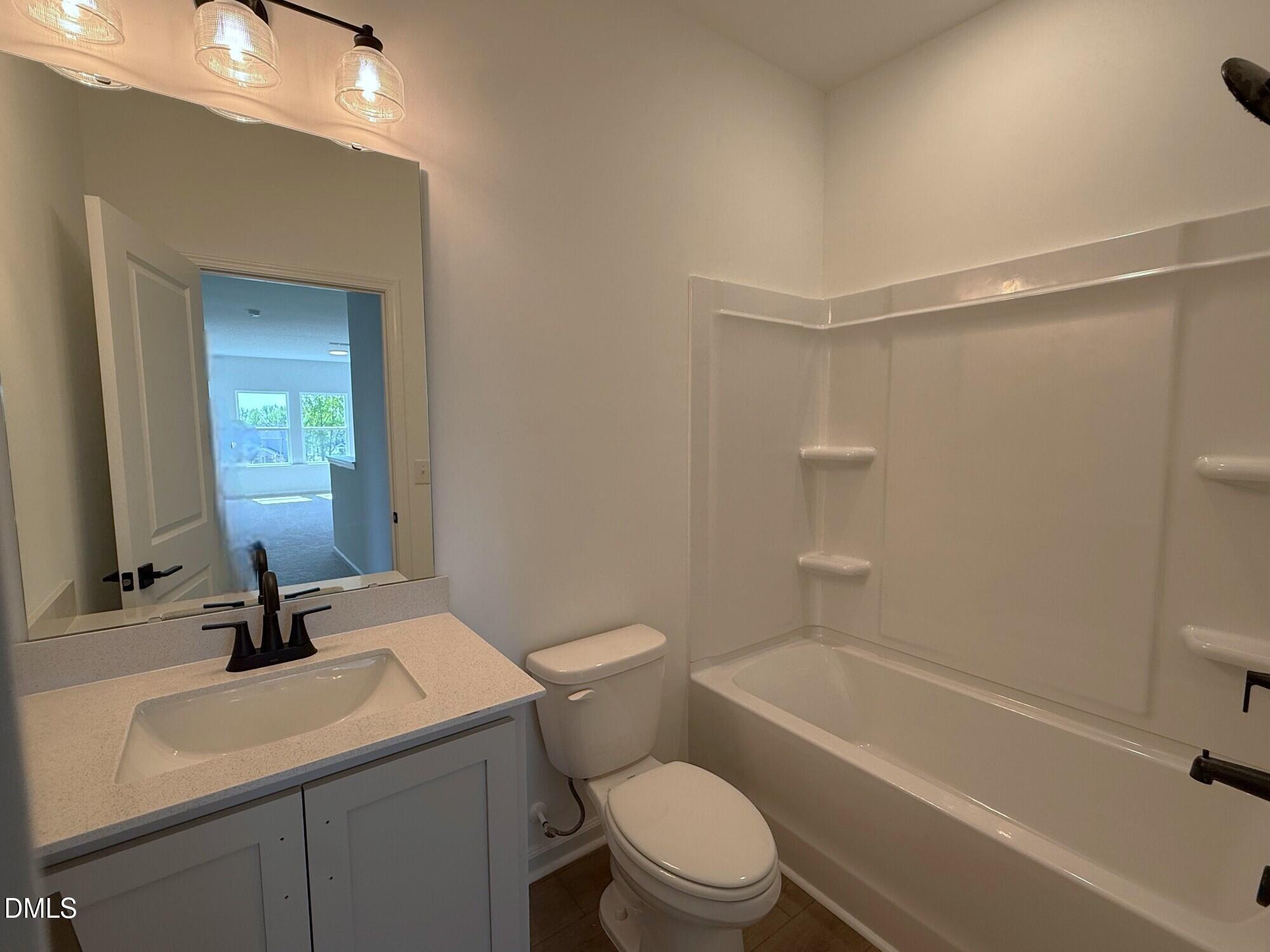 433 Contempo Court, Unit 3 Rolesville, NC 27571 - Photo 26 of 40 a bathroom with a bathtub shower sink vanity mirror and toilet