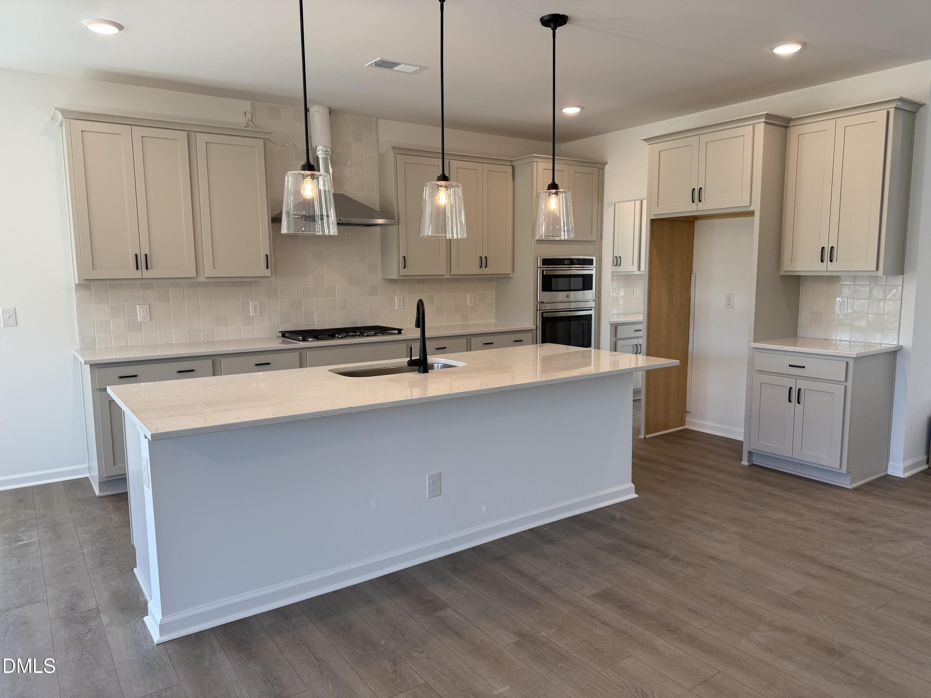 433 Contempo Court, Unit 3 Rolesville, NC 27571 - Photo 5 of 40 a large kitchen with stainless steel appliances granite countertop a sink a oven a refrigerator and white cabinets