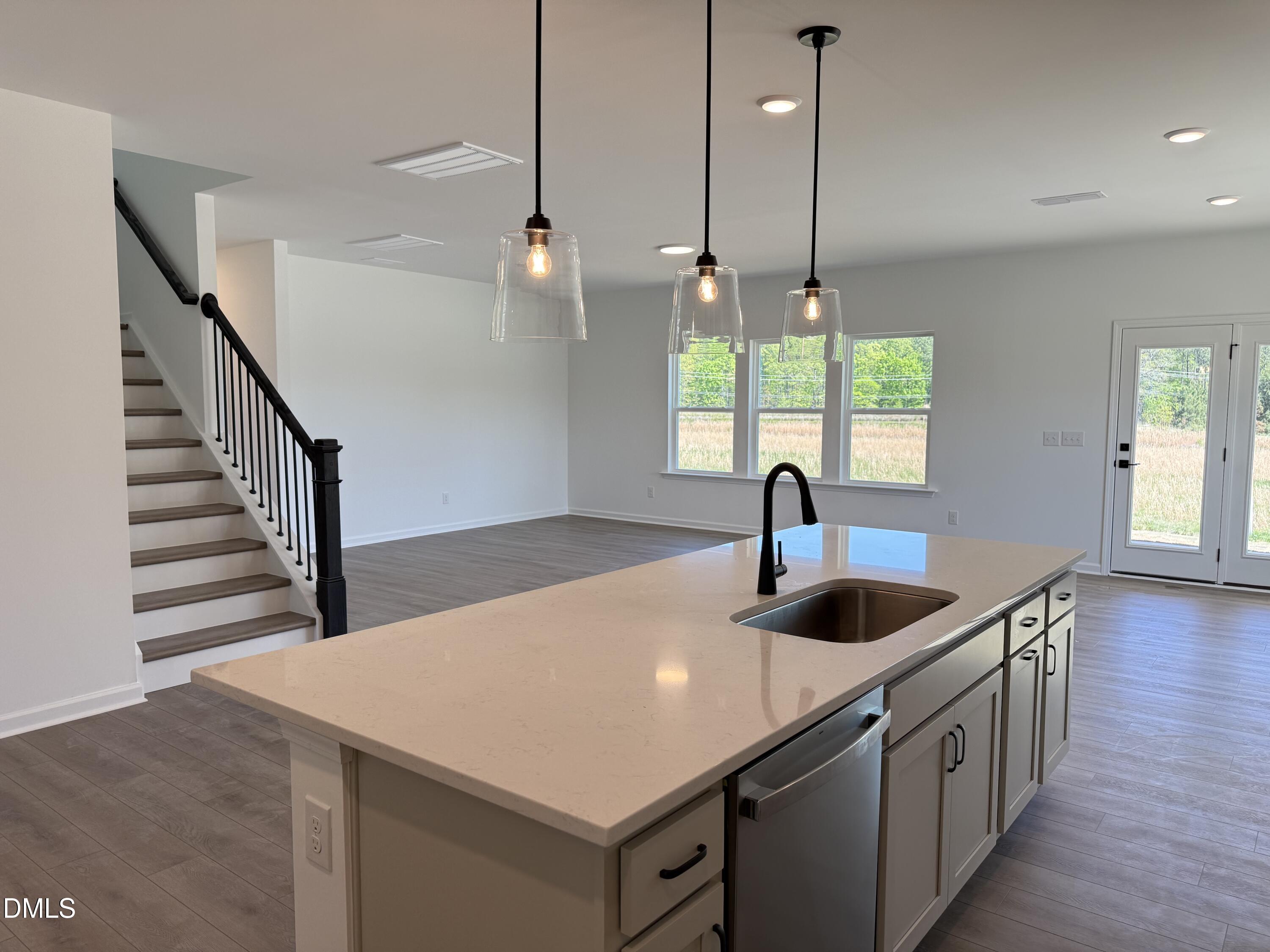 433 Contempo Court, Unit 3 Rolesville, NC 27571 - Photo 8 of 40 a kitchen with kitchen island a sink appliances and wooden floor