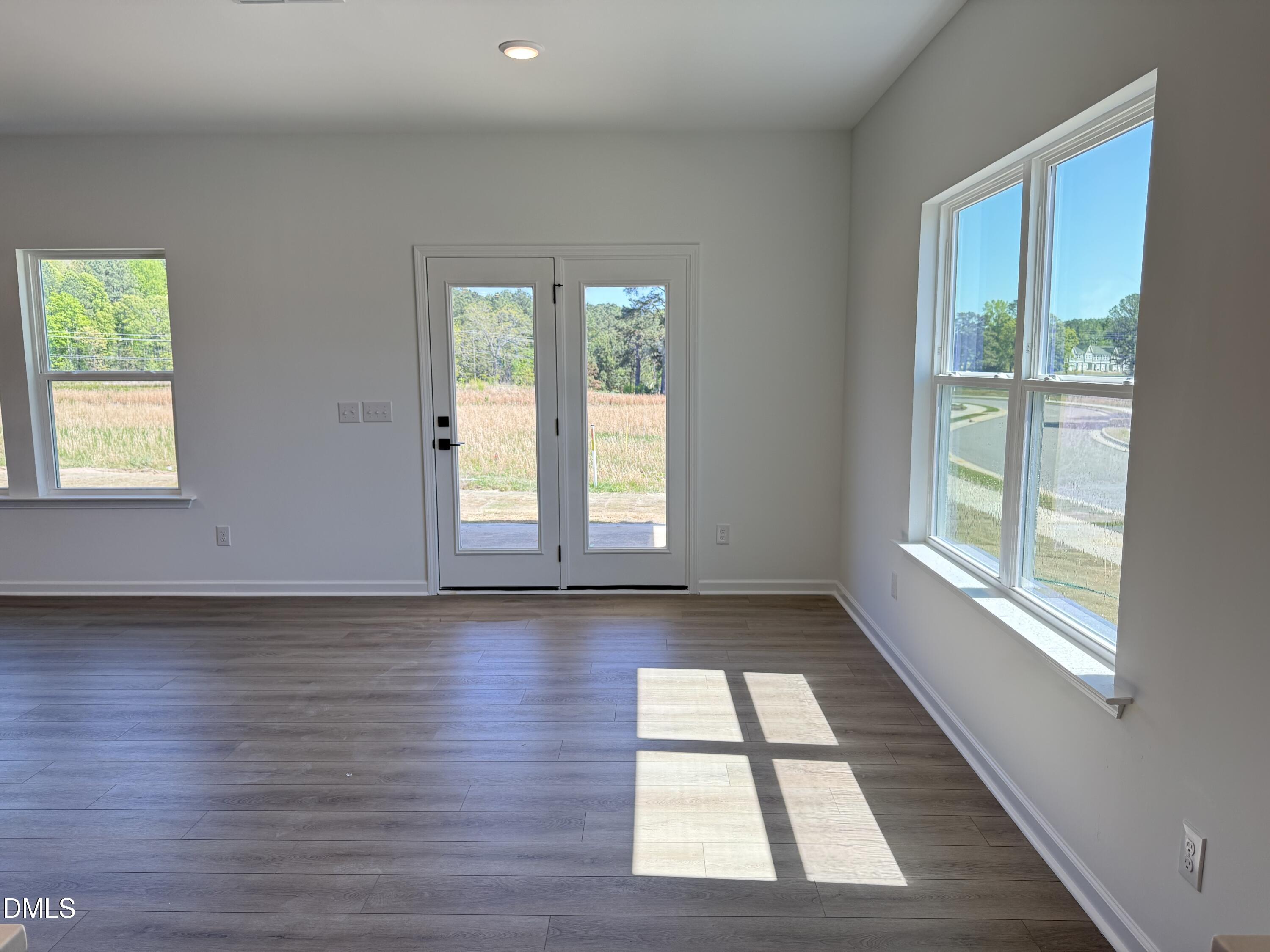 433 Contempo Court, Unit 3 Rolesville, NC 27571 - Photo 9 of 40 a view of an empty room with wooden floor and a window
